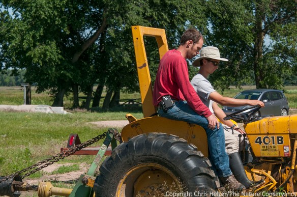 Nelson Winkel teaches Hubbard Fellow Evan Barrientos (in hat) how to drive a tractor.